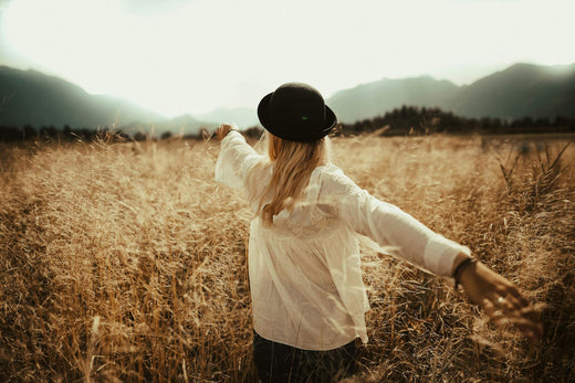 girl in field feeling happy